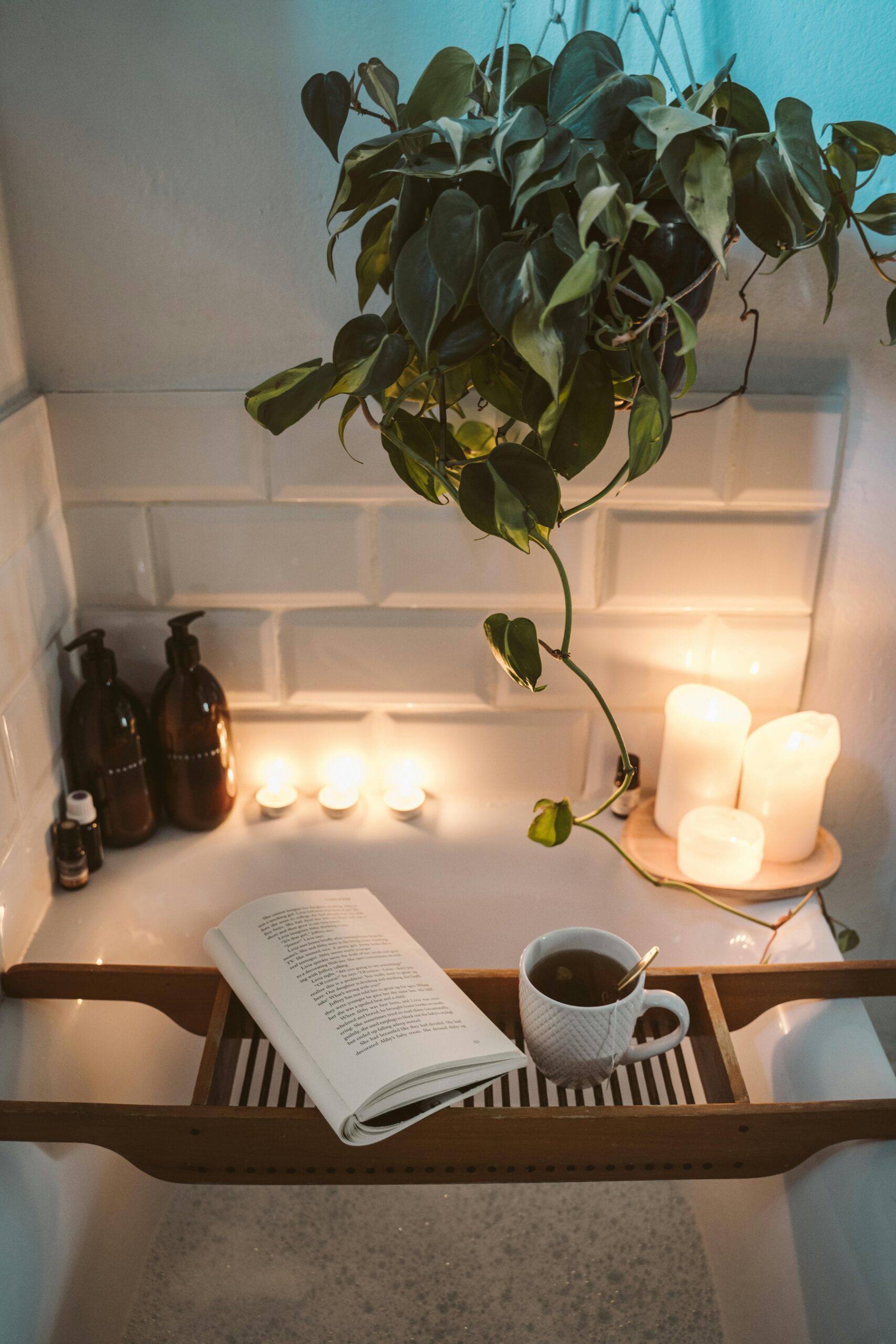 Relax in a cozy bathtub with candles, tea, and a book for a serene evening.